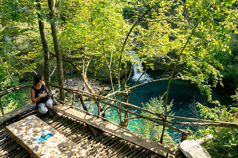 Photo of Albanian girl at restaurant overlooking the Blue Eye of Theth (the Blue Eye of the North) in Albania. This restaurant has the best views of the Blue Eye.