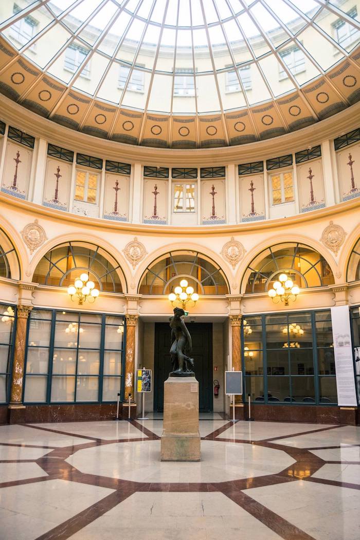 Photo of Galerie Colbert in Paris, one of the arcades of Paris. Get off the beaten path in Paris on a self guided walking tour of the passages of Paris. #Paris #France #Travel