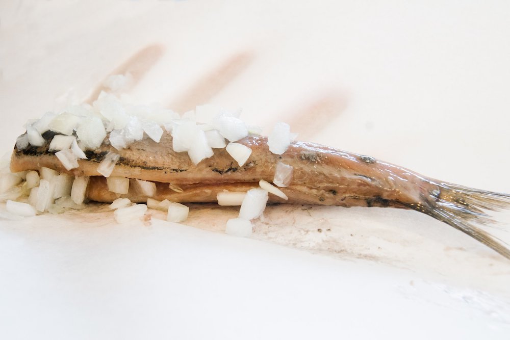 Herring, Haring, one of the most popular Dutch foods to eat in the Netherlands. This delicious raw fish is something to eat in Amsterdam! #amsterdam #holland #ravel 