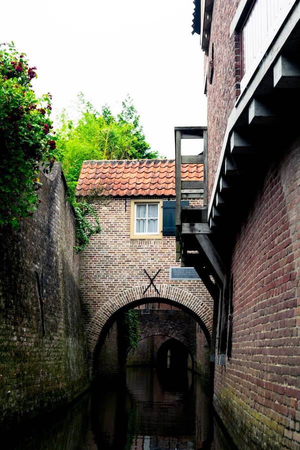 View of the Binnendieze, the medieval canals underneath the beautiful Dutch city of Den Bosch. Many skip this beautiful Dutch city, but you should include it in your Netherlands itinerary! #denbosch #nederland #travel #netherlands