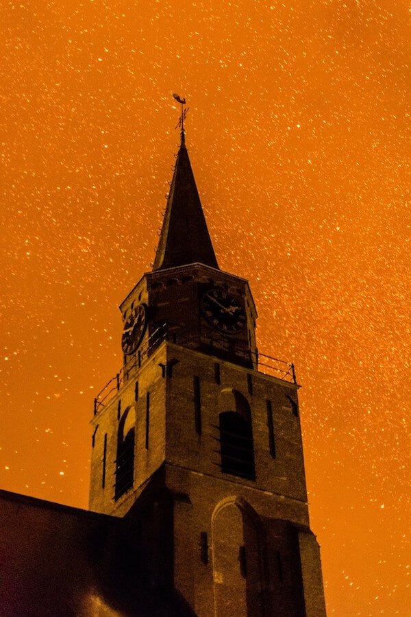 Haunting image of Scheveningen church on New Year's Eve with fire and ash....