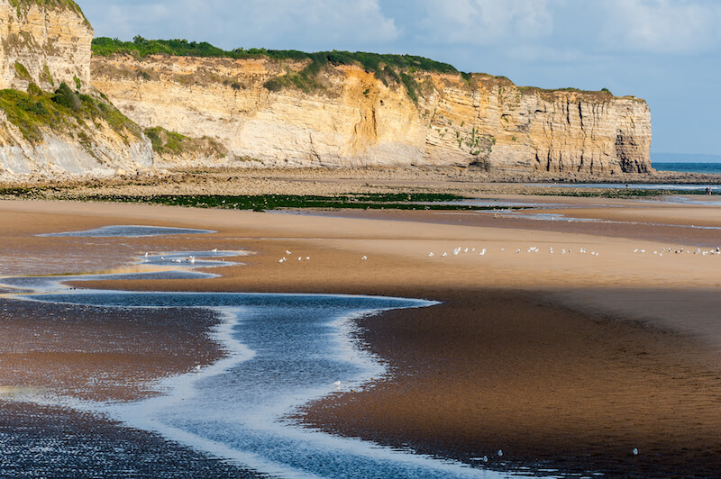 Omaha beach in Normandy France. Pay your respect to fallen soldiers while visiting Normandy on a road trip. #france #normandy #dday