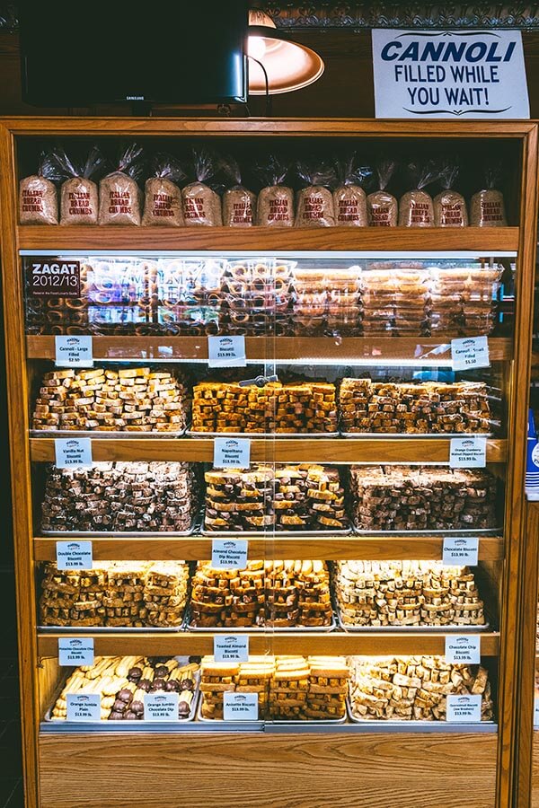 Schrank gefüllt mit frischem italienischem Gebäck, darunter Cannolis, in einer italienischen Bäckerei in der Arthur Avenue